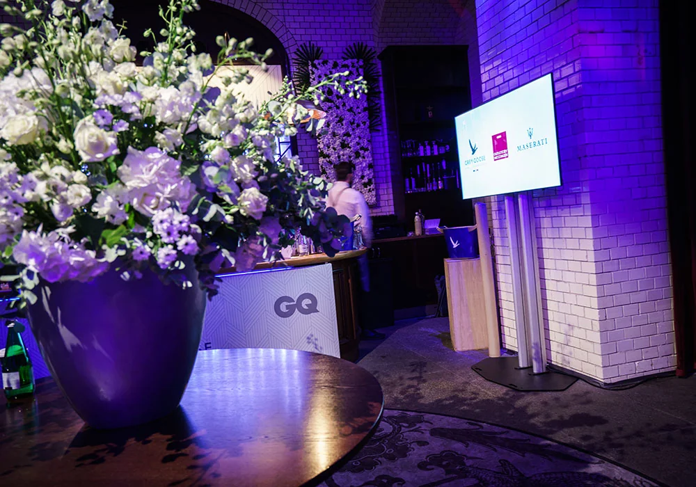 Gebrandete Bar mit GQ Logo und Blumenschmuck bei der Jubiläumsparty Berlin