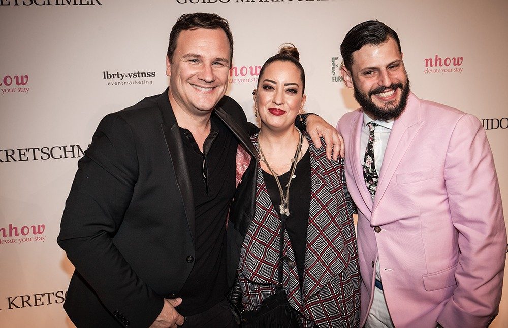 Drei Gäste vor der Pressewand der Guido-Maria-Kretschmer-Aftershow-Party in Berlin